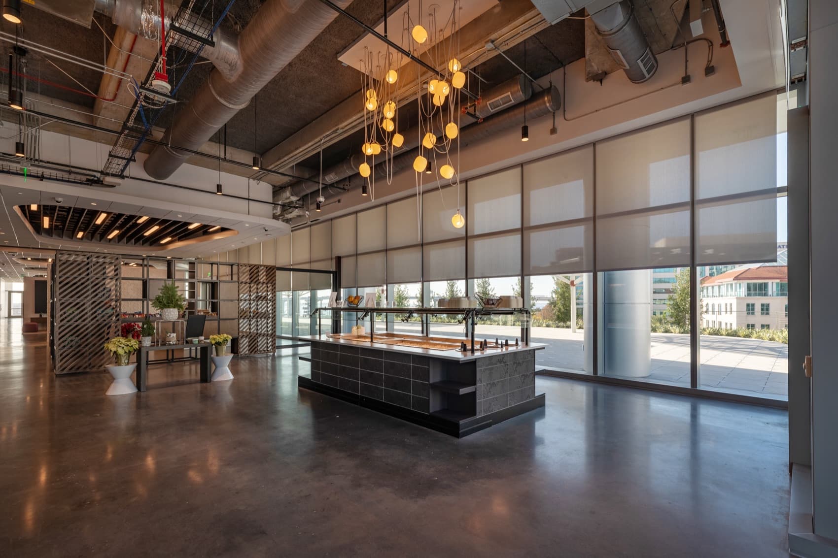 FIS World Headquarters — two-story café and servery with motorized shades on the window wall