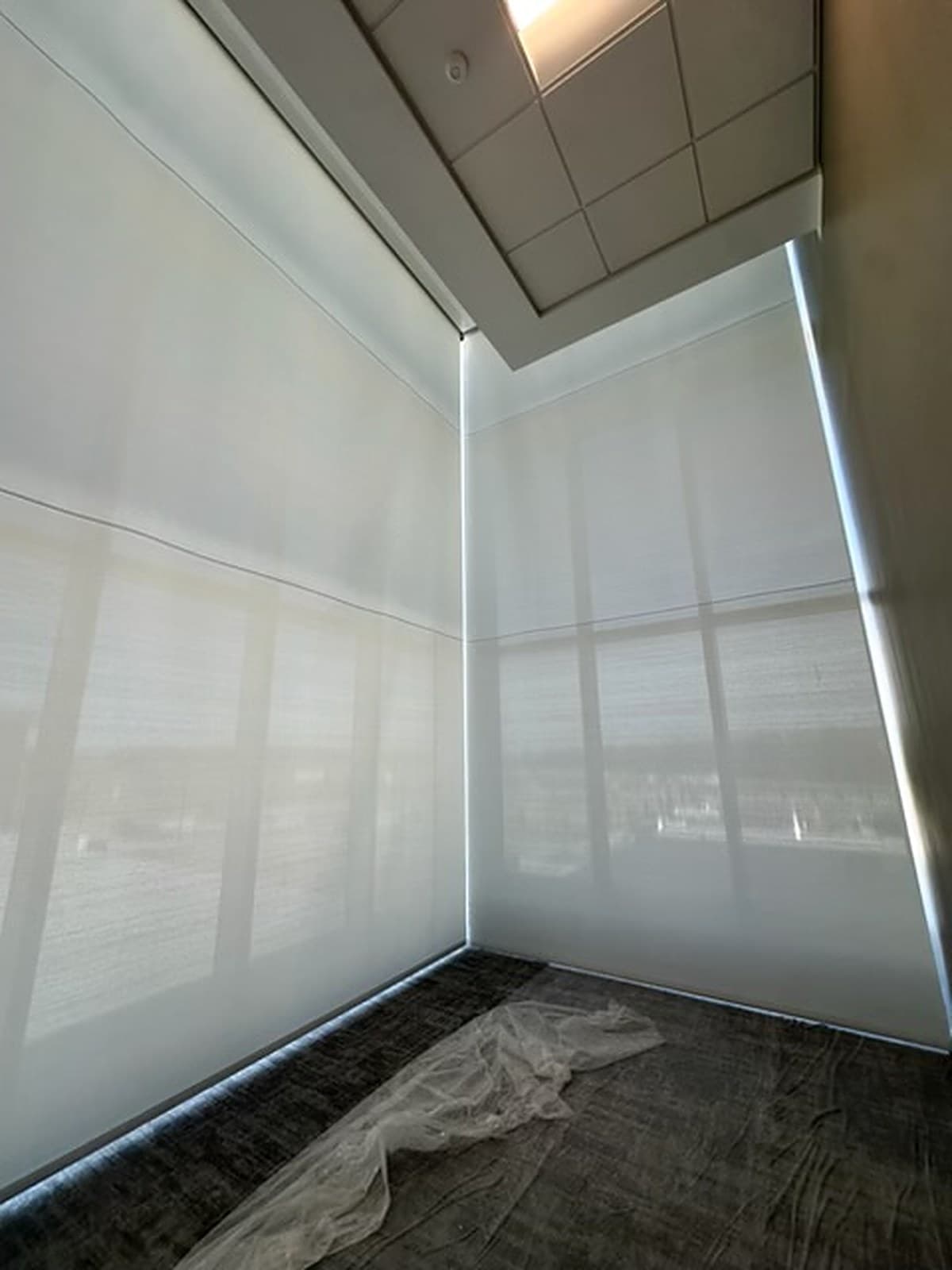 Tower Hill Insurance HQ — double-height corner glazing with sheer motorized roller shades lowered, Alachua, FL